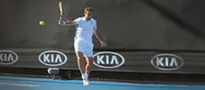 Un tennista che gioca su un campo da tennis blu