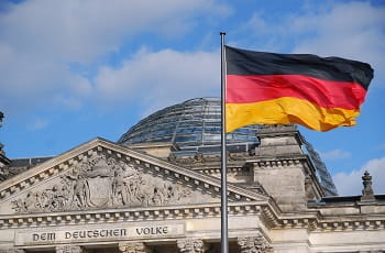 Il palazzo che ospita il Parlamento federale tedesco a Berlino e la bandiera della Germania