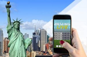 Statua della Libertà, skyline di New York e mano che regge uno smartphone per scommettere online.