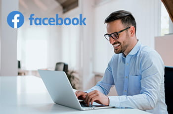 Persona al computer e logo Facebook